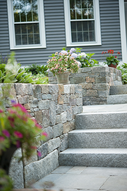 Bedford residence enjoys a new custom entry with stone walls by landscaping company Stone Blossom