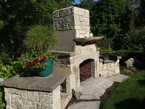 Custom outdoor fireplace for a landscape in Bedford NH by Stone Blossom