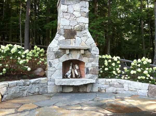 Landscape design in Bedford NH by Stone Blossom includes this outdoor fireplace