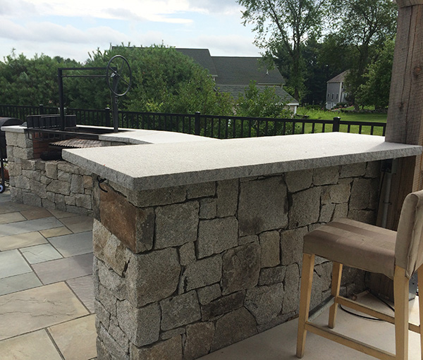 Outdoor bar and outdoor kitchen for this landscape designed by Stone Blossom Manchester NH