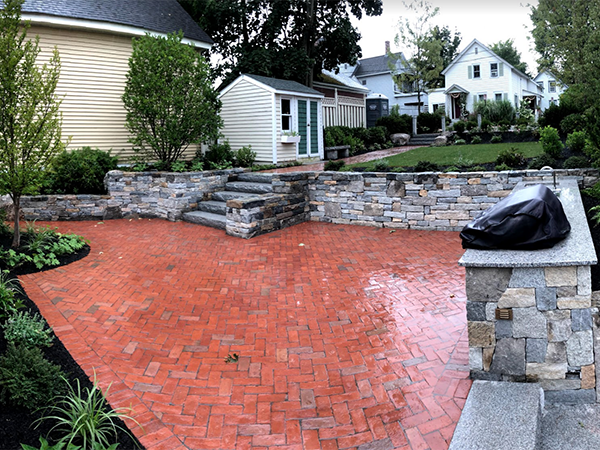 Brick patio with outdoor kitchen and stone walls in Concord NH